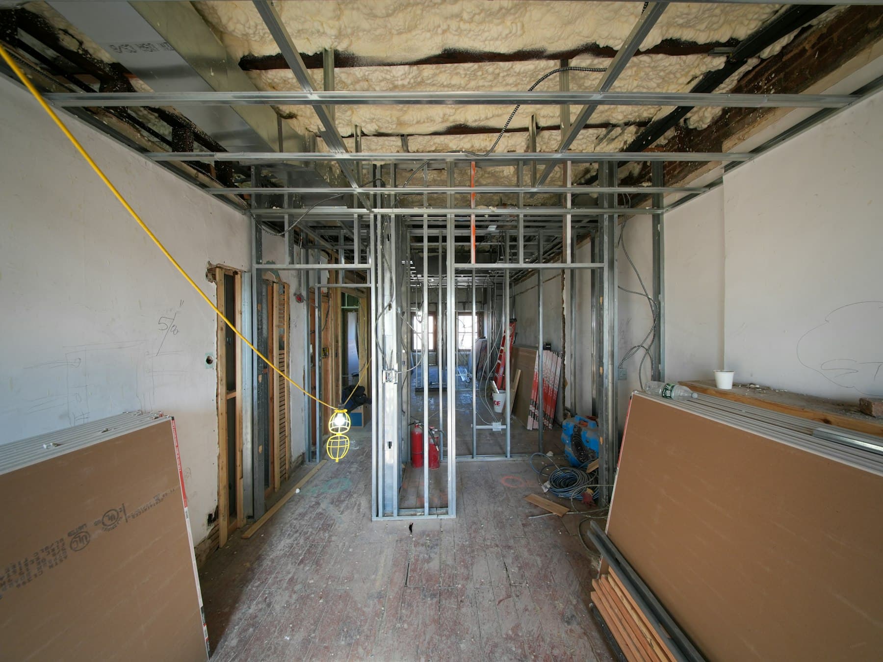 Appartement en travaux avec ossatures métalliques et gaines électriques au plafond