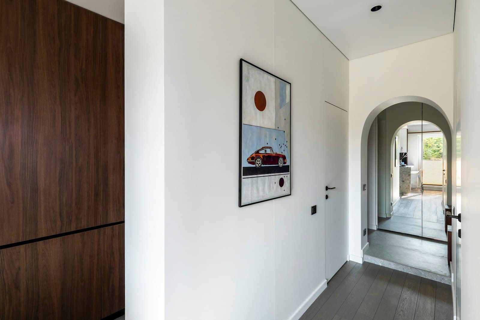 Entrée avec passage en arche et parquet foncé