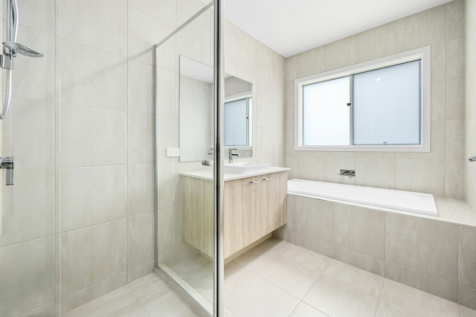 Salle de bain blanche, douche vitrée et baignoire