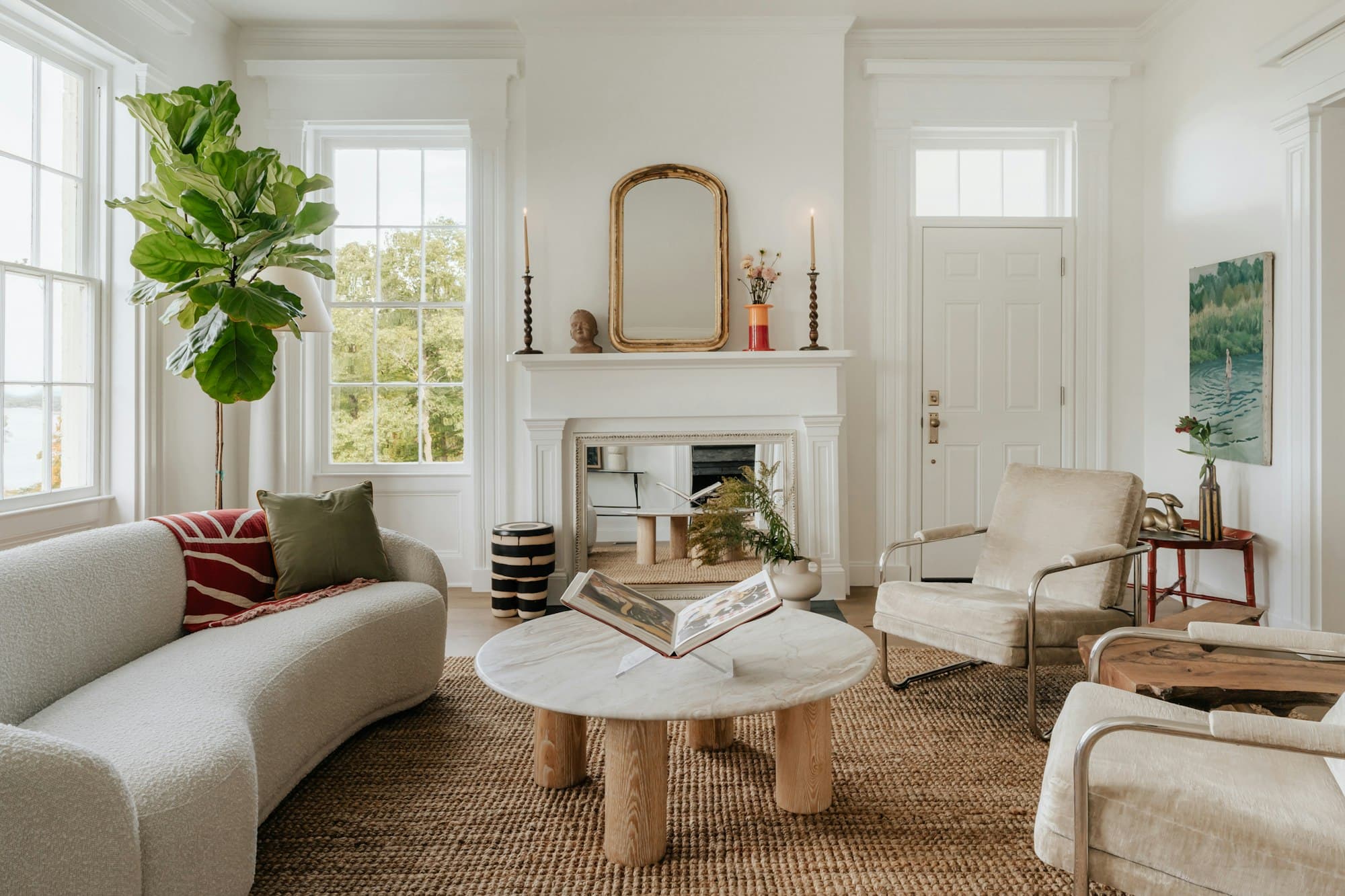Séjour de maison avec cheminée, canapé clair et table basse en marbre